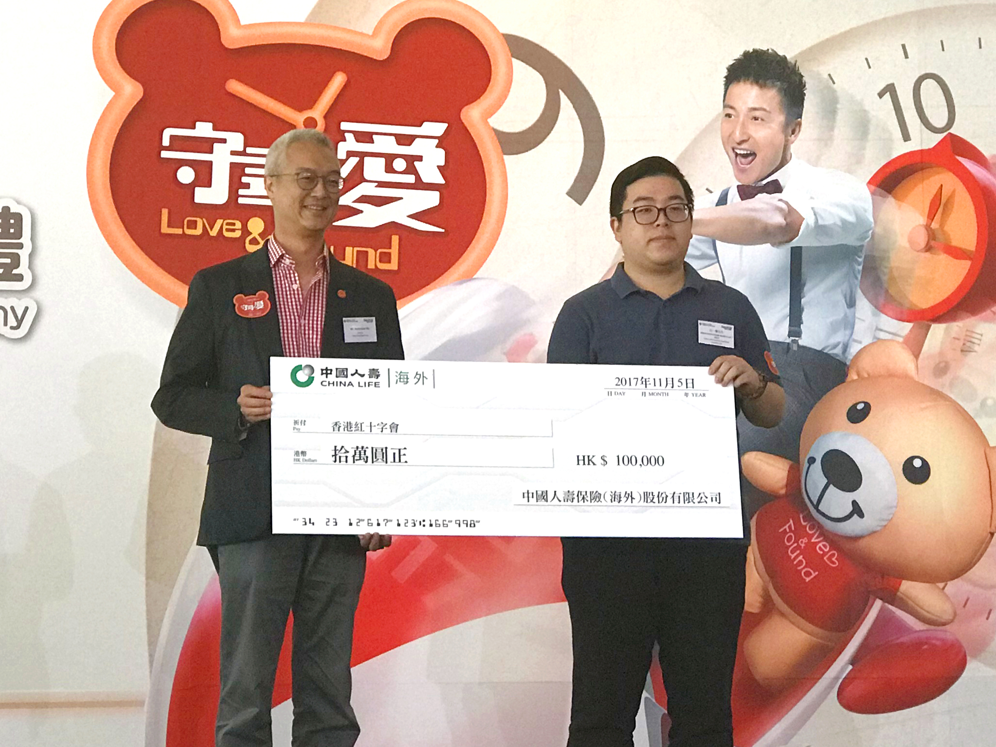 中国人寿（海外）康委会员工代表（右）上台致送捐款支票予香港红十字会总监何沛谦先生（左）
